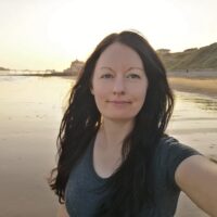 portrait-mature-woman-standing-beach-sunset