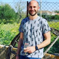 portrait-smiling-mid-adult-man-standing-against-fence